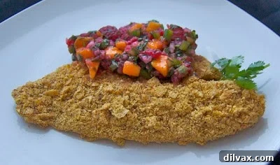 Seared Tilapia Tacos with Vibrant Raspberry Mango Salsa 2 Crispy Baked Tilapia with vibrant Raspberry Mango Salsa on a plate