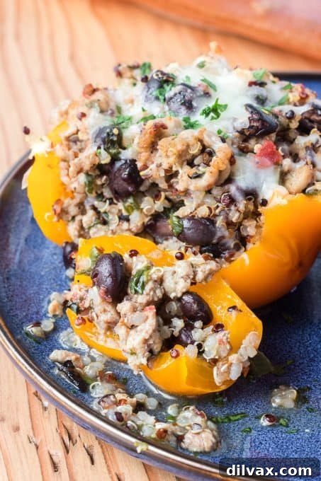 A close-up of a Quinoa, Black Bean and Turkey Stuffed Pepper with a bite taken out, showing the rich filling.