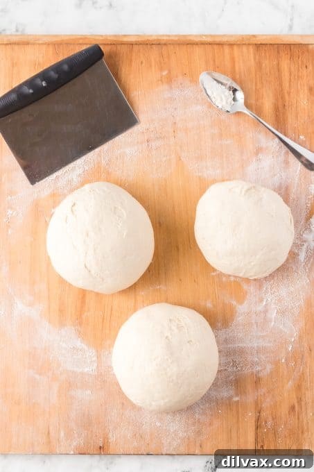 Pizzeria-Quality Pizza Dough At Home 8 Pizza dough made into three balls. Three dough balls resting in a bowl.