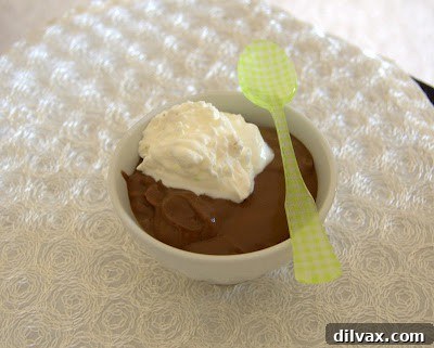 A close-up shot of rich chocolate pudding simmering in a saucepan, being whisked to perfection.