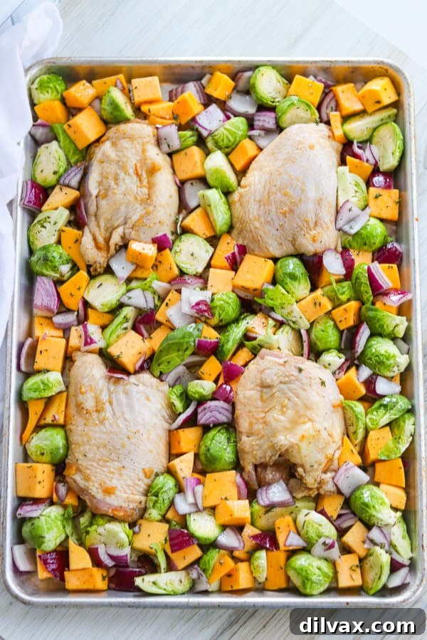 Savory Herb-Roasted Chicken and Vibrant Vegetables 4 Chicken thighs and various vegetables arranged on a baking sheet.