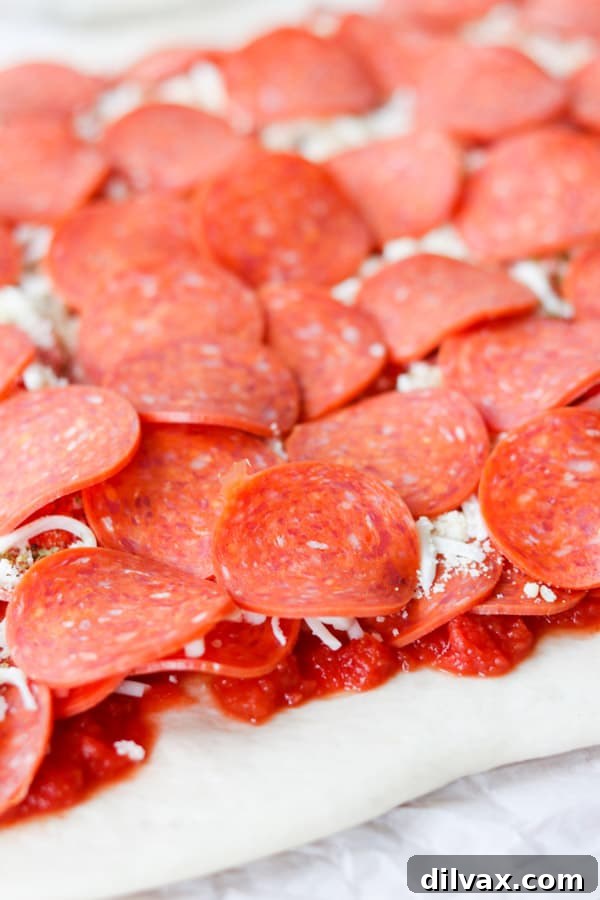 Abundant layers of HORMEL® Cup N' Crisp Pepperoni Bold generously covering fresh pizza dough, promising a rich flavor.