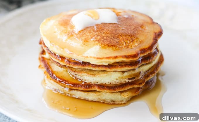 Syrup dripping off a stack of pancakes.