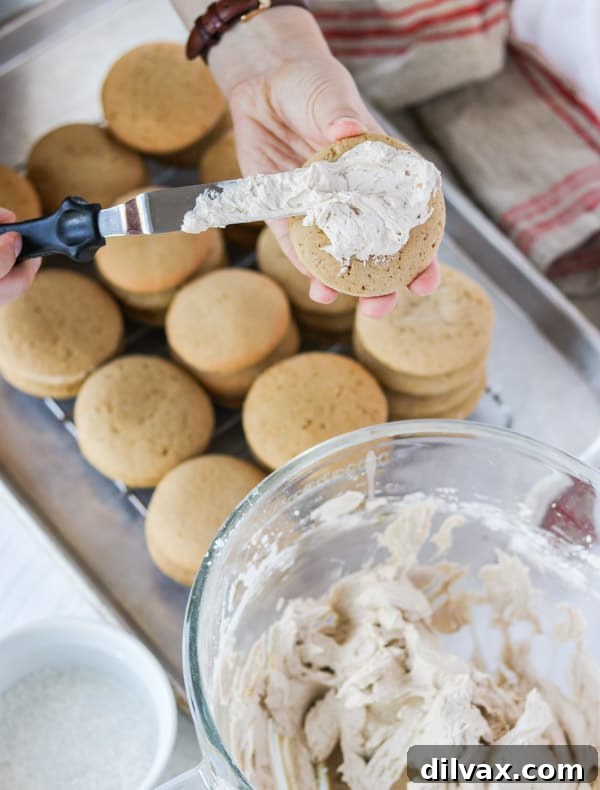 Frosting cookies A hand gently frosting a Root Beer Float Cookie with smooth root beer buttercream.