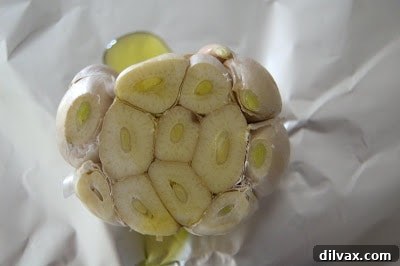 The head of garlic, drizzled with olive oil, ready to be wrapped in foil.