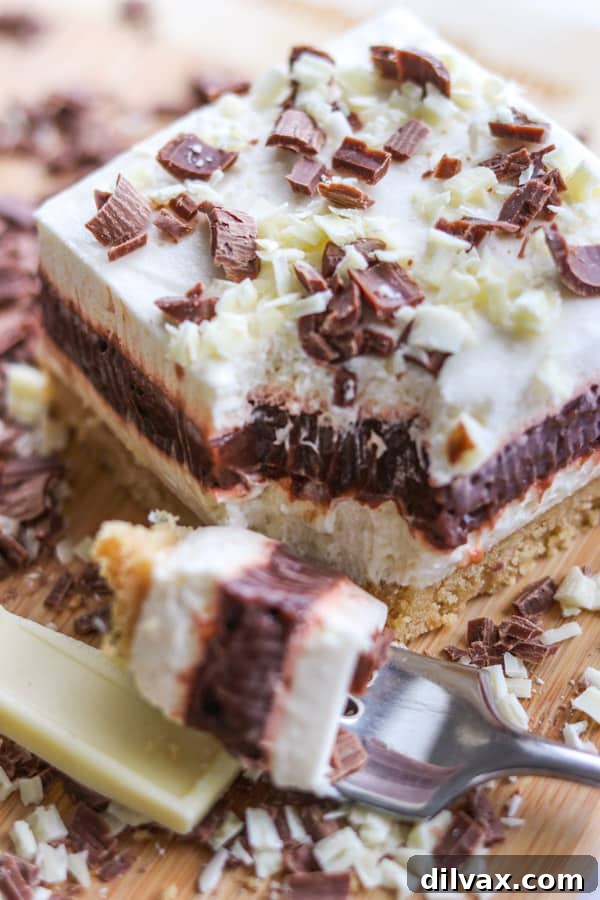 A bite taken out of an Irish Cream Dream Bar. A bite of Irish Cream Dream Bars on a fork.