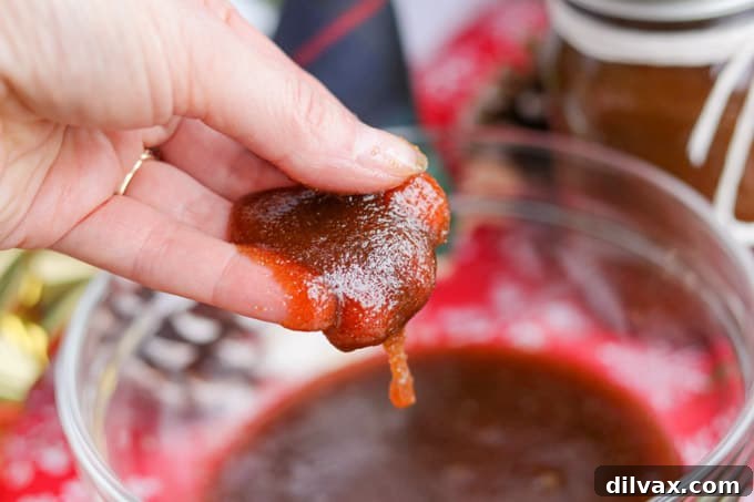 A simple and easy homemade brown sugar scrub in a jar and a hand holding some of it.