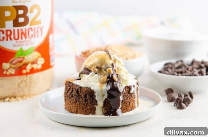 Ultimate Peanut Butter Chocolate Molten Cakes 2 Peanut Butter Chocolate Lava Cake topped with vanilla ice cream and peanut butter and chocolate drizzle, showcasing its gooey, molten center.