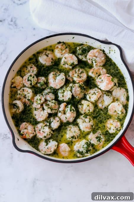 Zesty Lemon Garlic Shrimp Pasta 4 Close-up of shrimp sizzling in a skillet with garlic butter and lemon zest, showing them turning pink.