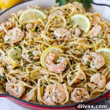 Zesty Lemon Garlic Shrimp Pasta 5 A skillet full of linguine with lemon, garlic, and shrimp, garnished with fresh parsley.