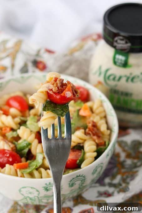 A forkful of Bacon Pasta Salad made with Marie's Creamy Ranch Dressing, ready to eat.