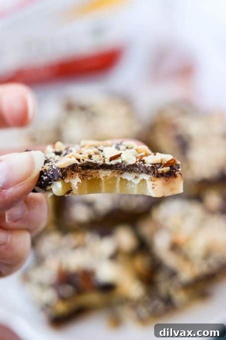 Silken Milk Toffee 7 A piece of condensed milk toffee with a bite taken out, revealing its chewy texture and almond bits.