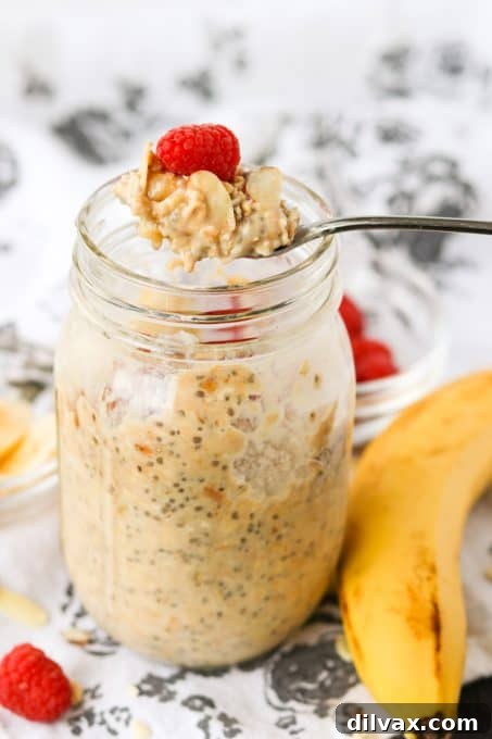 A spoon scooping a generous portion of creamy overnight oatmeal with banana, showcasing its delightful texture.