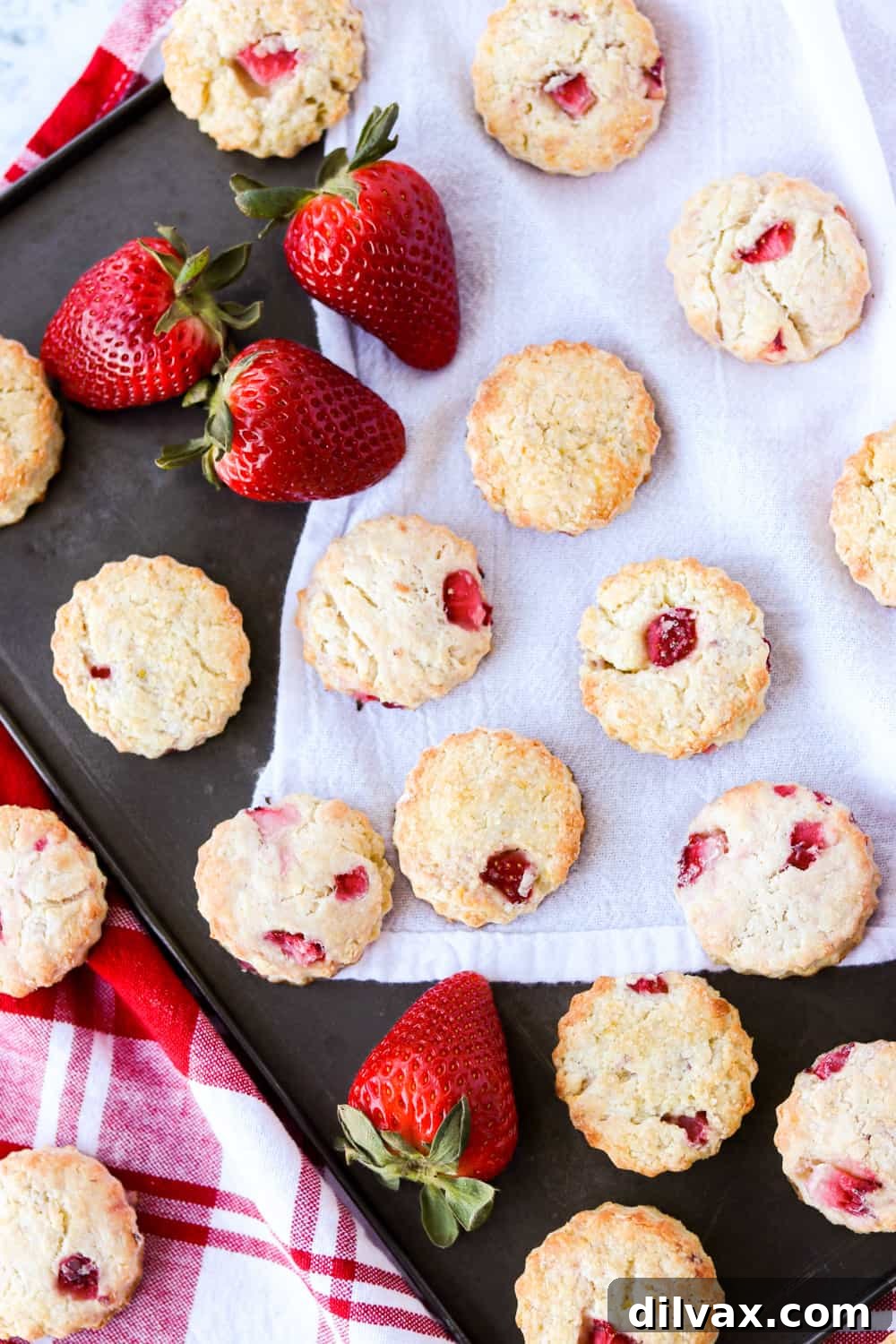 A pristine tray of freshly baked strawberry scones, each perfectly golden with a hint of raw sugar topping, ready to be enjoyed warm.