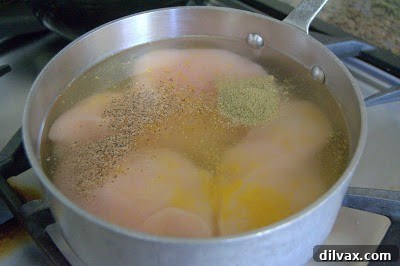 Chicken breasts simmering in a saucepan