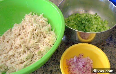 Adding shredded chicken to the buffalo dressing