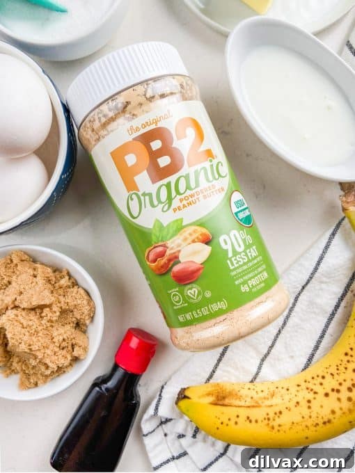 Jar of PB2 Organic Powdered Peanut Butter on a wooden surface.