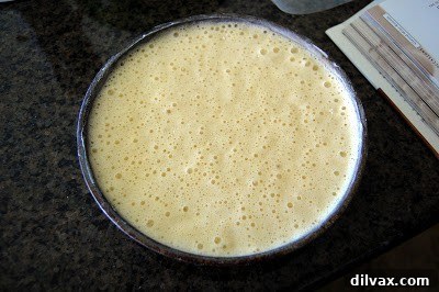 Arranging sliced fresh strawberries over the whipped cream layer.