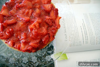 Applying the final layer of whipped cream to the top and sides of the cake.