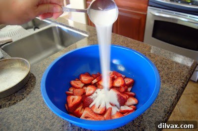 Ingredients for French Strawberry Cake, including flour, sugar, and eggs, laid out on a counter.