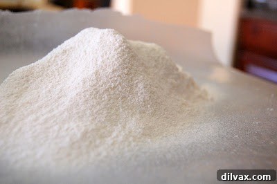 Pouring genoise batter into a prepared cake pan.