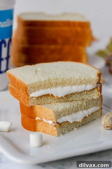 Effortless Fluffernutter Bliss 3 A close-up shot of a Fluffernutter sandwich, cut diagonally, revealing the perfect layers of creamy peanut butter and fluffy marshmallow spread.