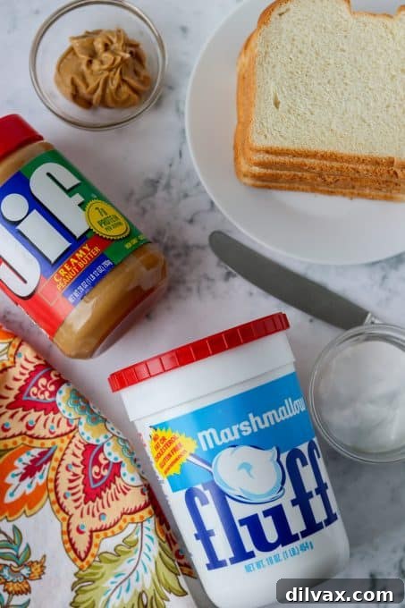 Effortless Fluffernutter Bliss 4 The essential ingredients for a Fluffernutter: slices of bread, a jar of creamy peanut butter, and the iconic blue-labeled Marshmallow Fluff.