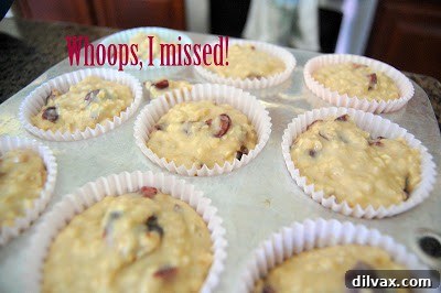 Juicy Cherry & Hearty Oat Muffins 9 Muffin batter scooped into paper-lined muffin cups in a baking tin.