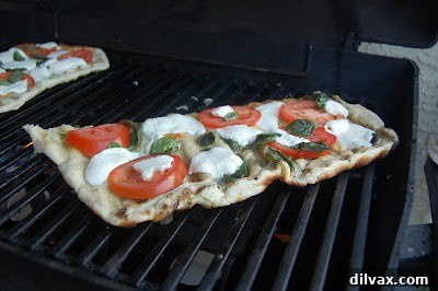 A freshly grilled Margherita pizza with melted cheese and basil.
