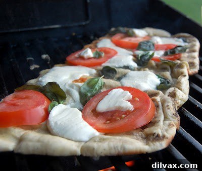 Sliced grilled Margherita pizza, showing the melted cheese and fresh toppings.