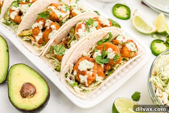 Tortillas filled with coleslaw and seasoned shrimp.