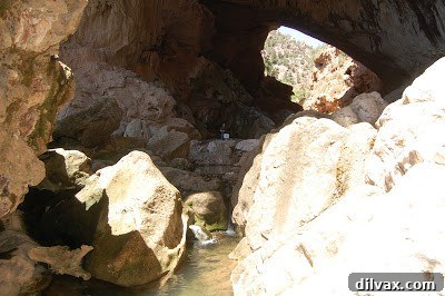 Inside the Tonto Natural Bridge, showing slippery rocks and the pool of water below, emphasizing no swimming.