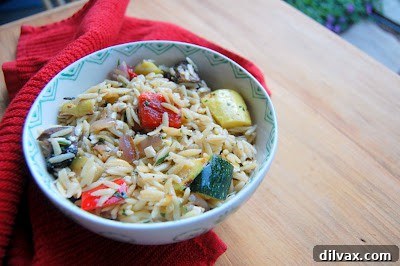 A colorful assortment of raw, thinly sliced zucchini, yellow squash, quartered red bell pepper, sliced Portobello mushrooms, and rings of red onion, meticulously arranged and ready for the grill.
