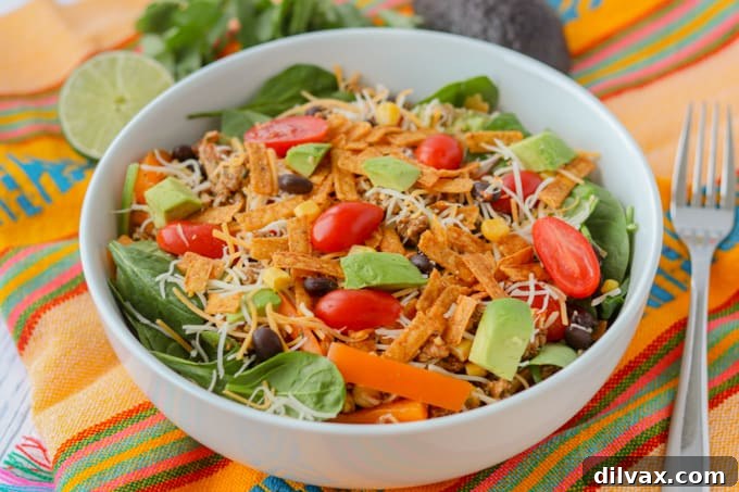 A vibrant and fully loaded chicken taco salad bowl, ready to be enjoyed.