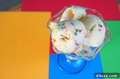 A charming close-up of Cake Batter Ice Cream in a sundae glass, artfully surrounded by a scattering of sprinkles.