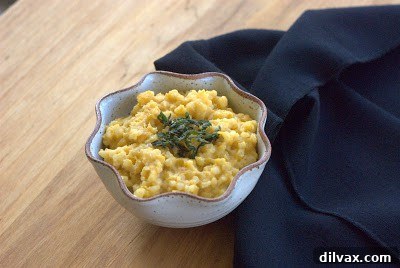 Butternut squash risotto served in a bowl, garnished with crispy sage and Parmesan.
