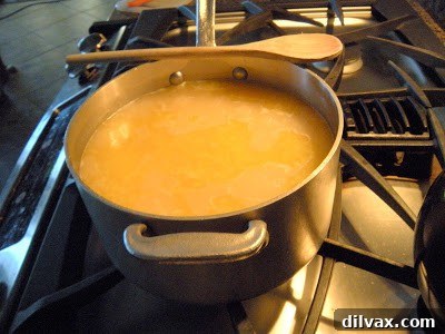 Arborio rice simmering in chicken broth in a large saucepan.