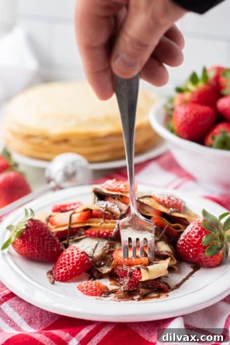 Decadent Strawberry Nutella Crepes 8 Taking a bite out of Strawberry Nutella Crepes.