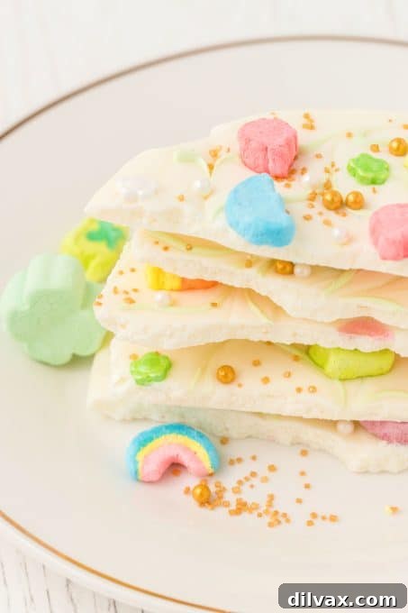 Rainbow Magic Bark 8 Close-up of white chocolate bark with cereal marshmallows and green swirls.
