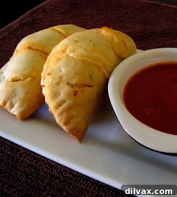 Bite Sized Pepperoni Calzones 7 Hand holding a freshly baked mini calzone, steam rising