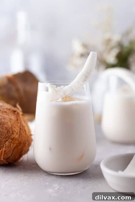 Tropical Coconut Bliss 3 A close-up shot of a creamy Coconut Cooler beverage in a tall glass, highlighting its smooth texture and refreshing appeal.