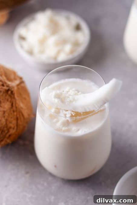 Tropical Coconut Bliss 8 A glass of Coconut Cooler garnished with a delicate slice of coconut, capturing its fresh and inviting look.