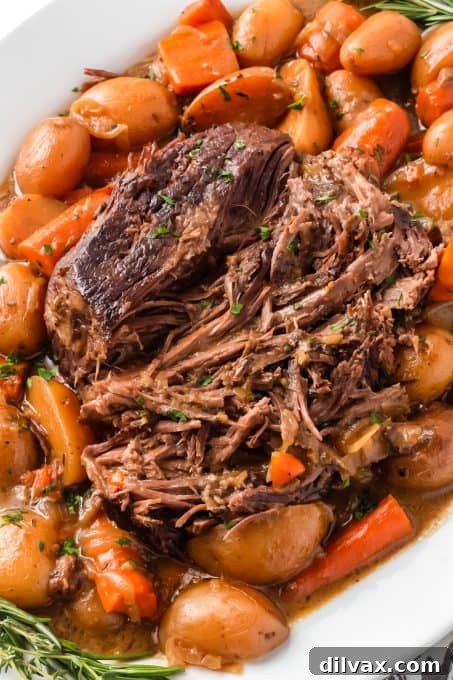 A tender roast surrounded by carrots and potatoes.