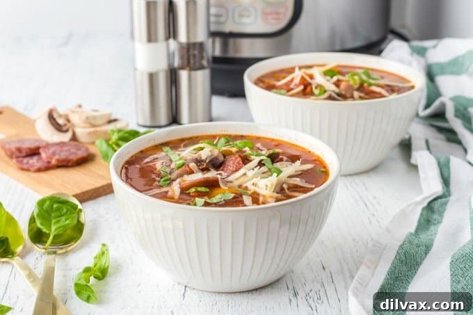 A steaming bowl of Instant Pot Pizza Soup, garnished with fresh basil and melted mozzarella cheese, with a rustic background.