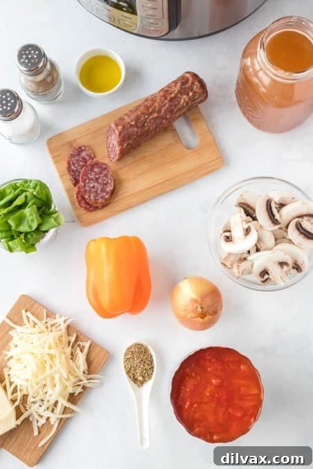 A selection of fresh ingredients laid out for Pizza Soup, including diced tomatoes, mushrooms, bell peppers, onions, pepperoni, and fresh basil.