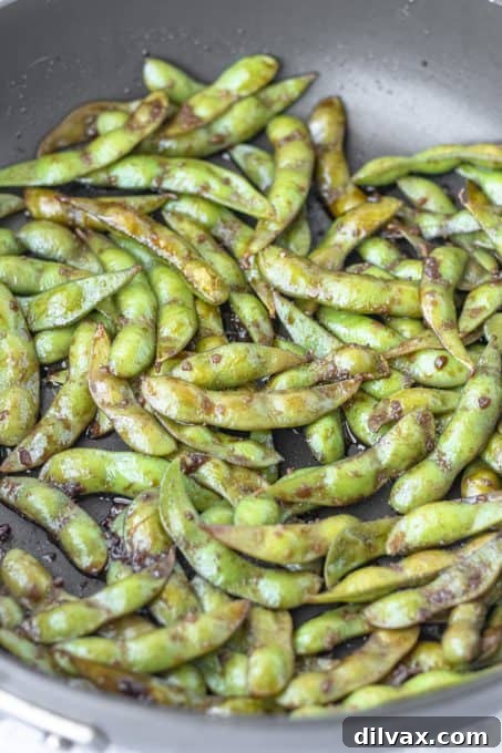 Savory Garlic Edamame 5 Edamame being sautéed in soy sauce, garlic, and salt.