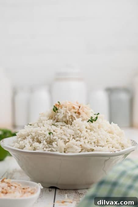 Fragrant Coconut Rice 7 A bowl of fragrant coconut rice, ready to be served, garnished with fresh herbs.