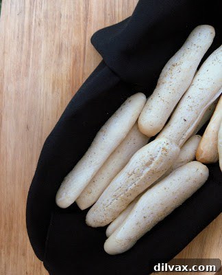 Close-up of freshly baked, golden-brown Olive Garden style breadsticks, glistening with garlic butter and herbs, ready to be enjoyed.