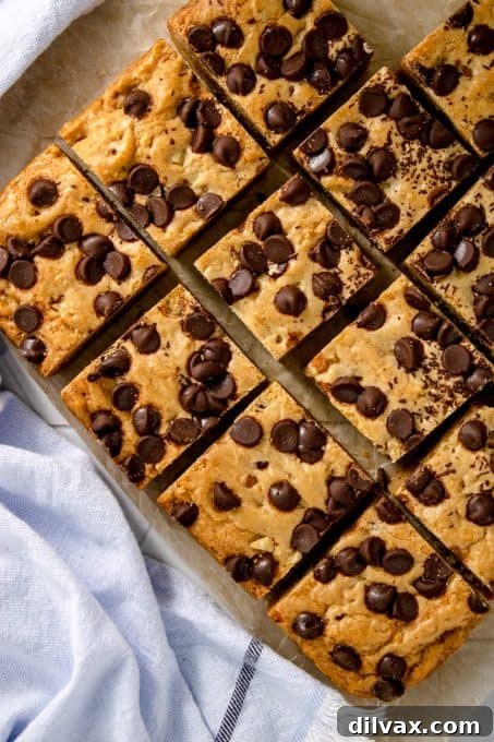 A stack of chocolate chip blondies, showcasing their thick, chewy texture and abundance of chocolate chips.