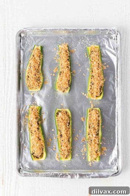 Hearty Mushroom Onion Zucchini Bake 6 Stuffed Zucchini ready for the oven, arranged in a baking dish.